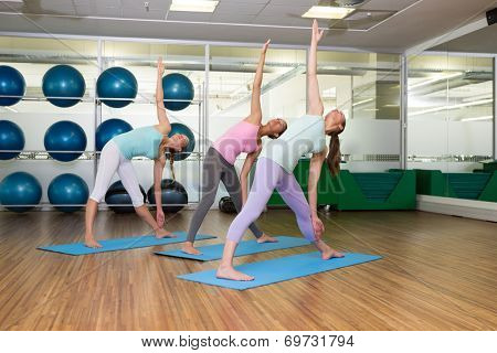 Yoga class in extended traingle position in fitness studio at the leisure center