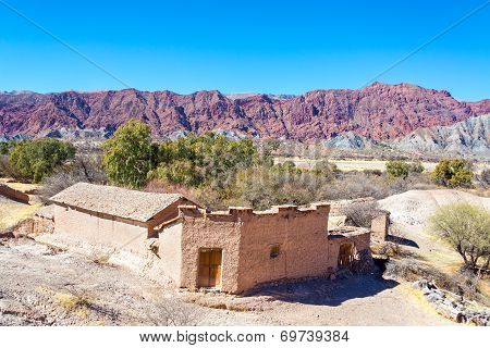 Rustic Adobe Building And Red Hills