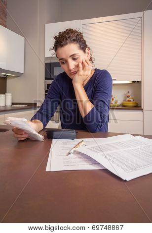 Unemployed and divorced woman with debts reviewing her monthly bills