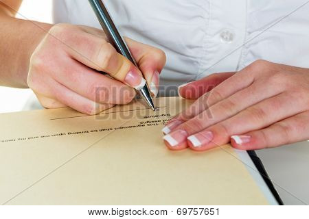 a woman signs a contract or a will with a fountain pen.