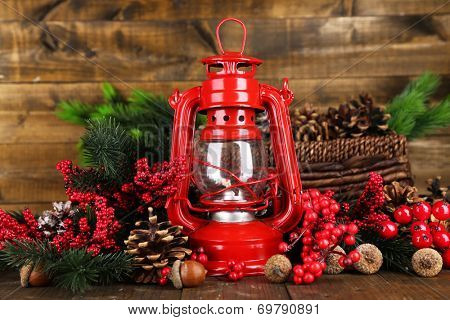Red kerosene lamp on wooden table on wooden background
