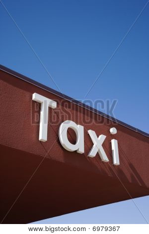 Taxi panneau sur un mur marron