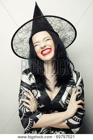 Funny Witch. Young happy woman with canival hat. Studio shot.
