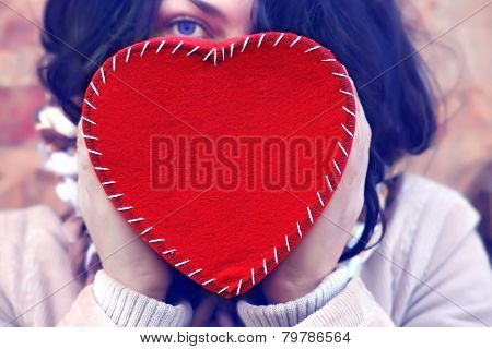 Young woman holding a red heart