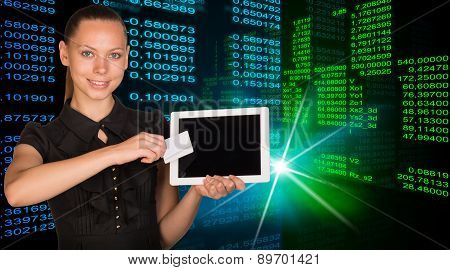 Smiling young woman holging tablet and card
