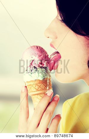 Young woman eating tasty ice cream