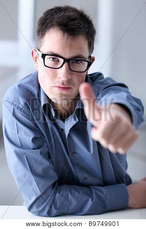 Man in home office showing his thumb, okay, sure,