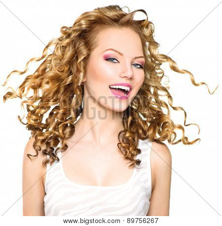 Beauty model girl with blowing Blonde curly hair. Portrait isolated on white background. Healthy wavy hair. Hairstyle. Beautiful smiling young woman. Beautiful face, natural make up. Long permed hair