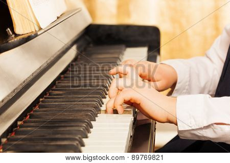 Child's hands playing on the piano-keys