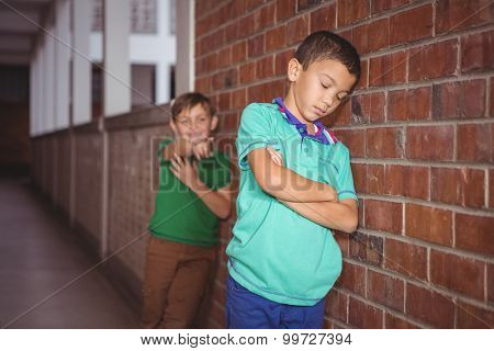 Student being bullied by a fellow student on the elementary school grounds