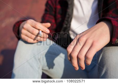 Close Up Of Teenage Boy Smoking Cigarette Outdoors