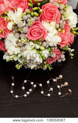 Vintage wedding bouquet with gold chain arranged in form of word Love