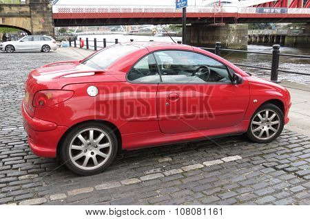 NEWCASTLE UK - CIRCA AUGUST 2015: red Peugeot 206 car (new model) parked in a street