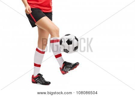 Close-up on the legs of a female football player jugling with a ball isolated on white background 