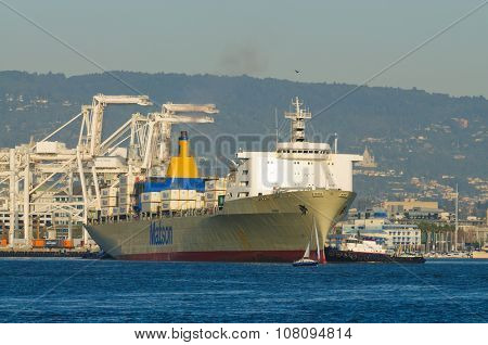 Alameda, CA - March 9, 2015: Oakland Container Shipyard, San Francisco Bay the Matson container ship "MANOA" maneuvering into dock