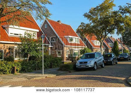 Picturesque Residential Houses And Parked Autos In Small Dutch Town Zwanenburg, The Netherlands