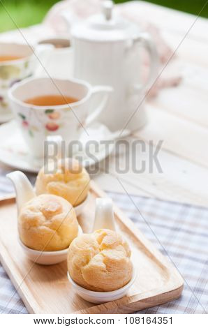 Cream Puff(choux Cream) With A Cup Of Tea On White Wooden Board, Afternoon Tea Relaxing Time Concept