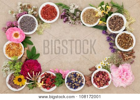 Herbal medicine flower and herb selection forming an abstract background  border over handmade hemp paper background.
