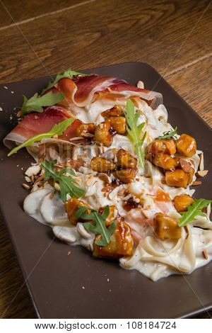 Decorated tagliatelle with cheese sauce, mushrooms and chicken