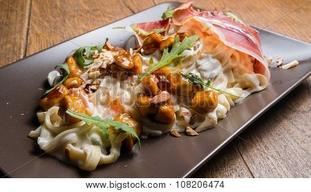 Decorated tagliatelle with cheese sauce, mushrooms and chicken