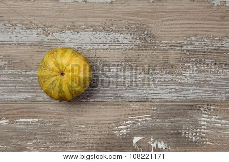 Striped Small Pumpkin Alone On Grunge Table Top View Isolated