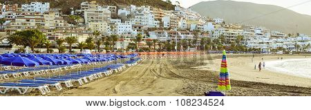 Sandy Beach With Blue Parasols And Sunbeds, Los Cristianos, Tenerife, Spain
