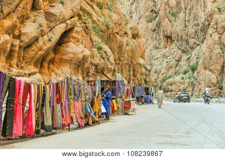 TINERHIR, MOROCCO, APRIL 11, 2015: Local sellers and their stands with souvenirs and fastfood on shore of Todgha river in Todgha Gorge
