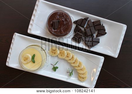 Banana and chocolate pudding with cliced banana, chocolate tiles and m