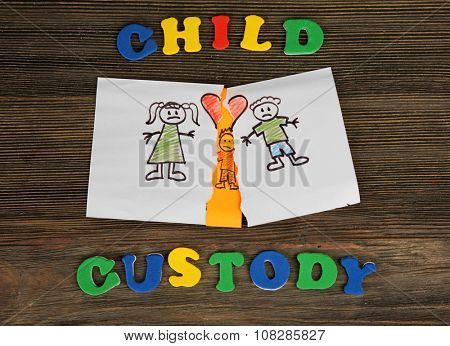 Torn apart drawing of a family on wooden background