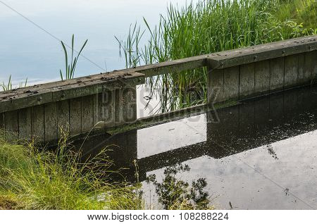 Wooden Weir Reflected In A Ditch