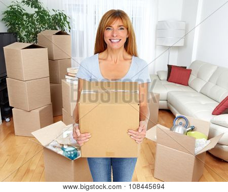 Beautiful smiling  lady with moving box in a new apartment.