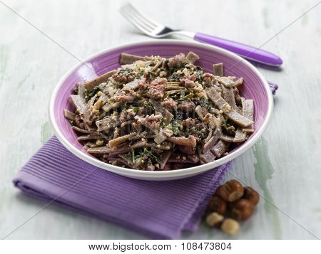 pizzocheri with sausage spinach and hazelnut selective focus