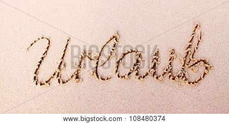 Word  Urlaub written in sand.