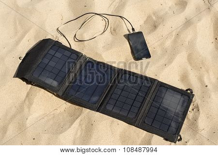 Portable Solar Panel Is On The Beach Charges Mobile Phone.