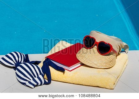 utensils for a nice relaxing vacation day lying next to a swimming pool. recreation on vacation.