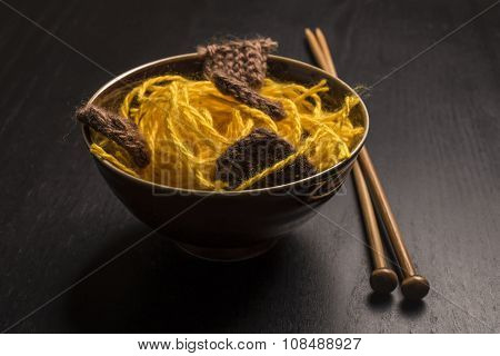 Food Knitted From Woolen Thread Lies On A Plate, As A Japanese Dish Of Meat And Noodles, Lie Next To