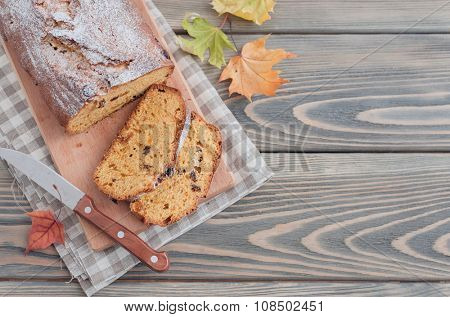Homemade cake with dried apricots and raisins on wooden background.  Autumn still life.