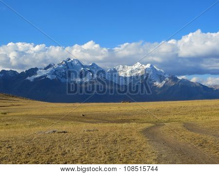 Off the beaten path Empty Rural dirt road in the desert in front of large mountains in the andes in latin america