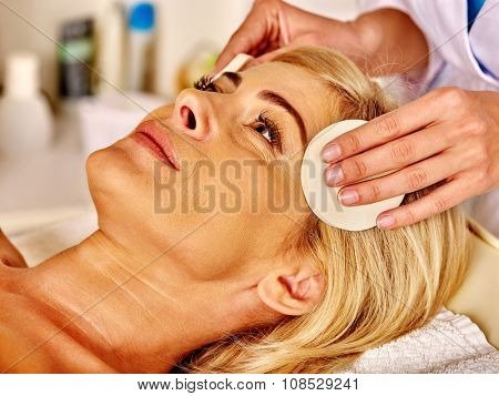 Portrait of woman middle-aged take face cleaning in spa salon.
