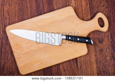 Knife on cutting boardon a woodwn table