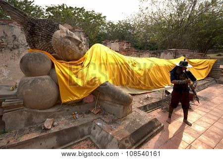 Ancient Warrior Posing Front Of Reclining Buddha.