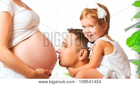 Happy Family. Father And Child Kissing Belly Of Mother Pregnant