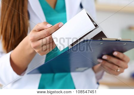 Close-up View Of Female Doctors Hands Holding Patient's Medical Record