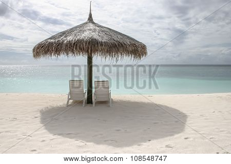 Beach Chairs With Umbrella In A Cloudy Sunny Day