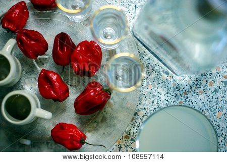 Red pepper, some glasses, alcohol in a bottle