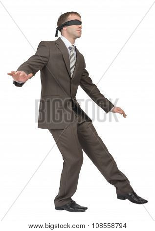 Man walking gingerly with band on his eyes