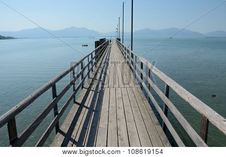 Long Wooden Pier At Chiemsee Lake In Germany