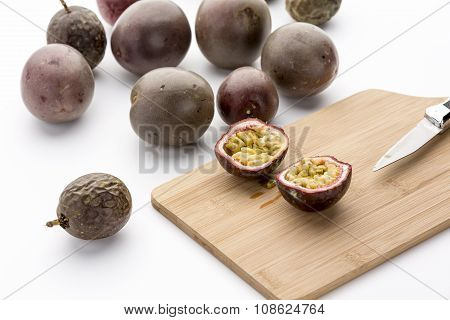 Freshly Halved Passion Fruit On A Bamboo Board