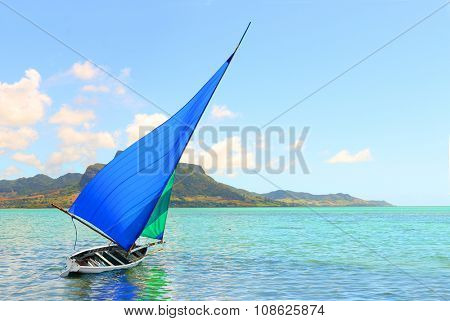 Sailboat in Mahebourg bay with Morne Brabant on background. Mauritius island.