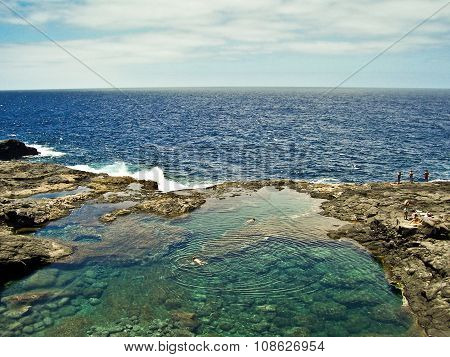 People Diving In A Natural Basin In The Rocks Coastline Of Lanzarote